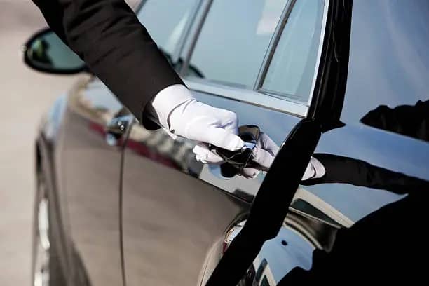 chauffeur opens door for business man who book black car service in Atlanta